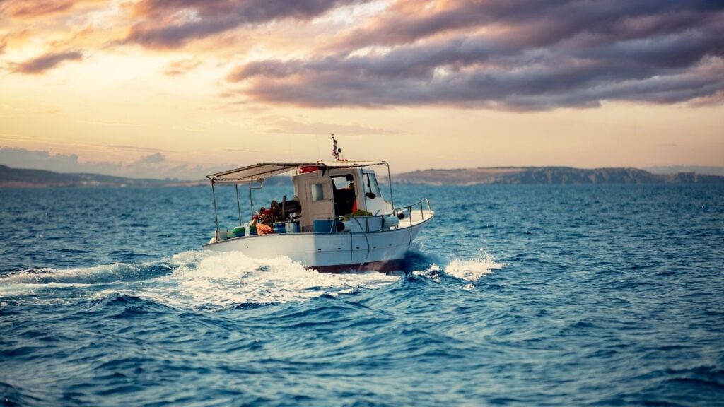 A fishing boat on the Mediterranean sea at sunset looking for Mediterranean seafood